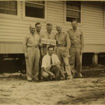 6 men in front of a house.